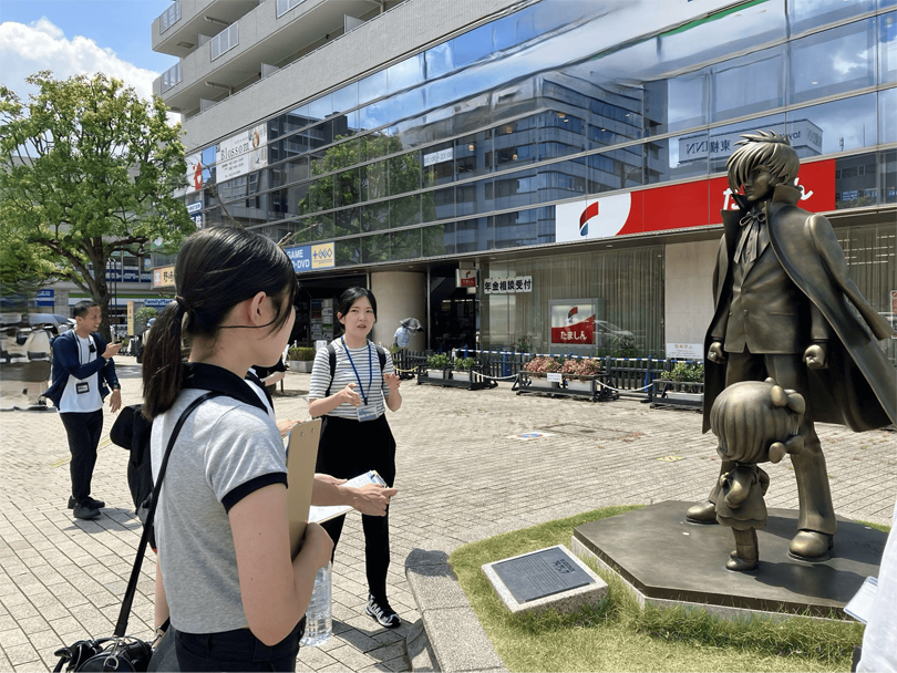 「ブラック・ジャック＆ピノコ像」について市職員の説明を受ける