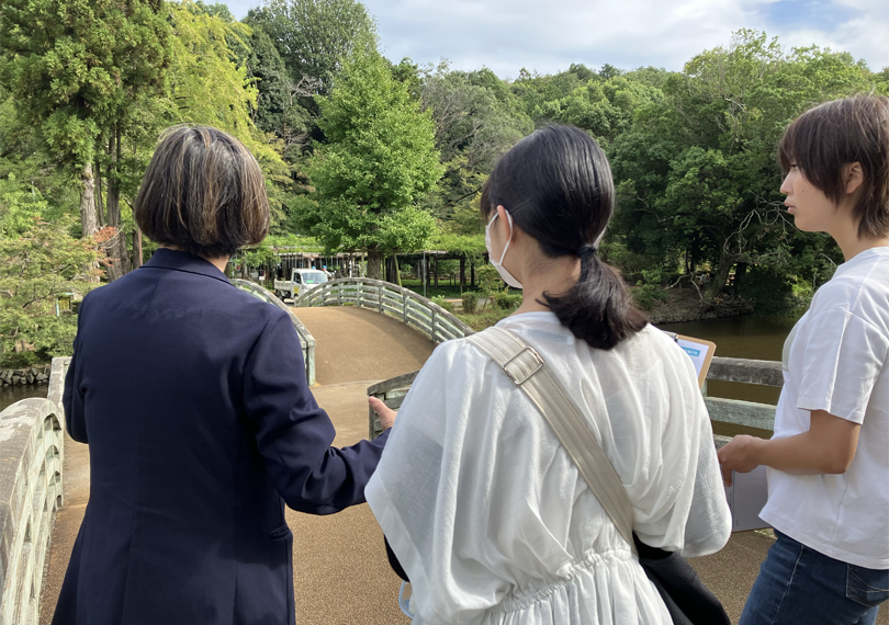 タイコ橋を望みながら説明を聞く学生